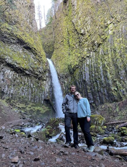 Tyler and I both wearing our favorite pairs of hiking pants in front of a waterfall.