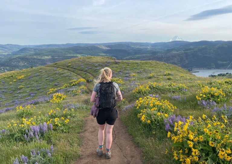 Myself hiking with the Osprey Tempest 20 in a field of wildflowers.
