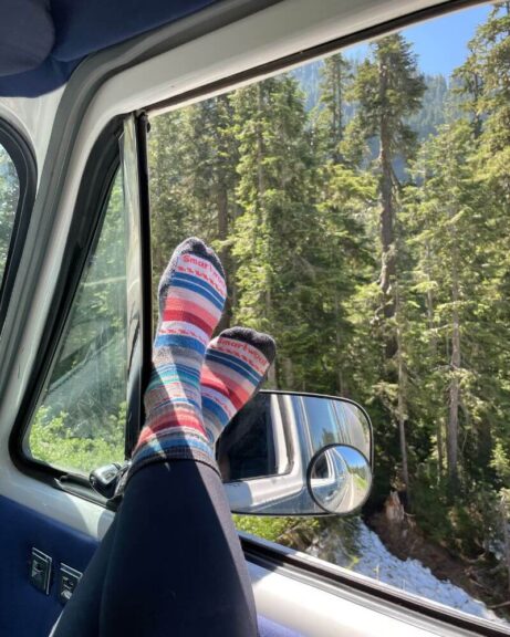 My pink and blue Smartwool socks on my feet, out the window with trees behind them.